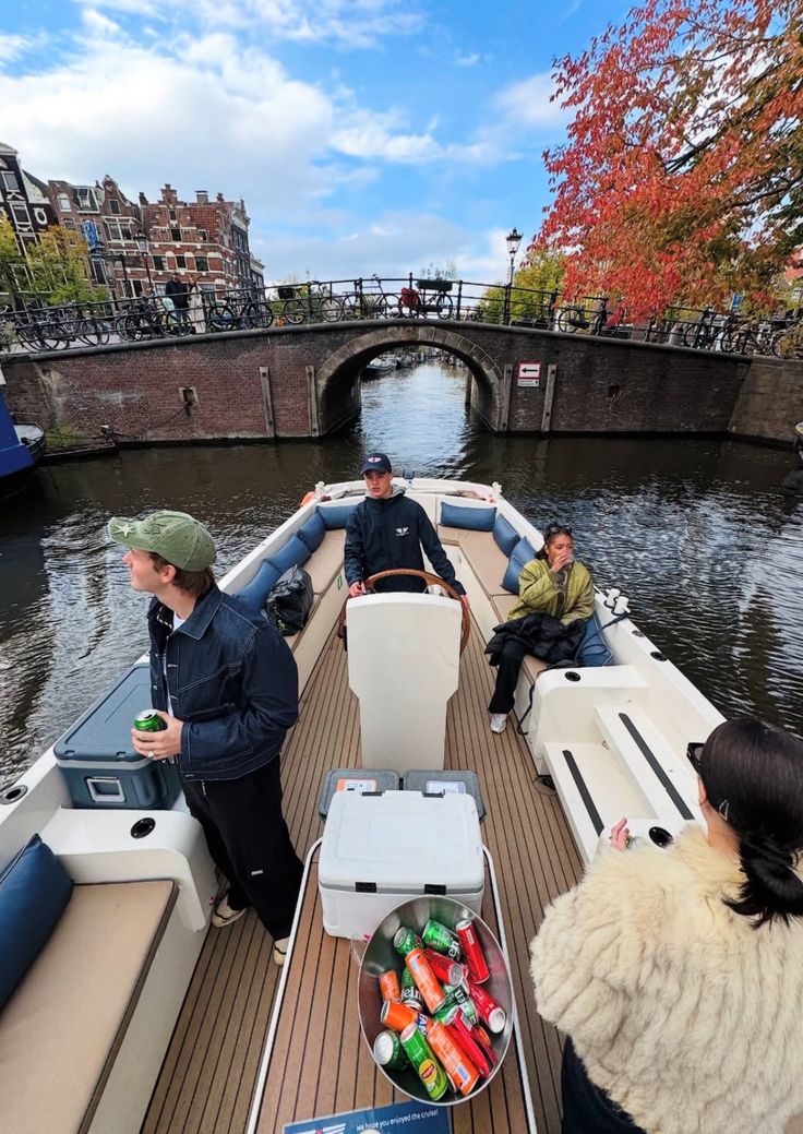 Open boat passing under a canal bridge in Amsterdam